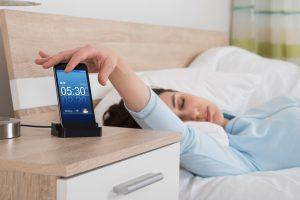 Woman Snoozing Alarm On Mobile Phone