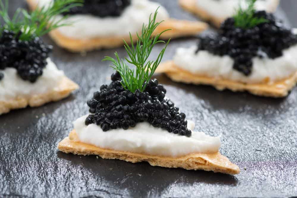 crackers with cream cheese and black caviar