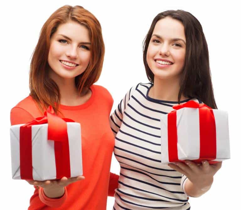 two smiling teenage girls with presents