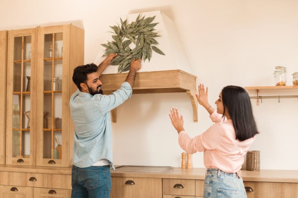 DIY home improvement supplies including paint, lighting fixtures, and textiles on a wooden table